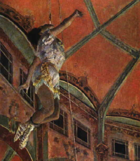 Miss La La, an Afro-german aerialist is shown from below as she flies through the air holding herself up by only her jaw.